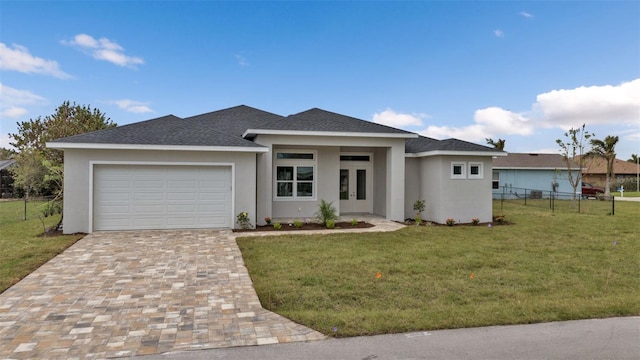 prairie-style home featuring a garage and a front lawn