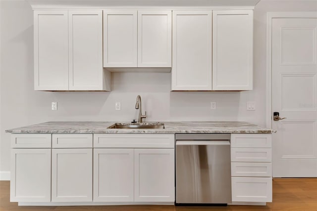 kitchen featuring light stone countertops, stainless steel dishwasher, sink, light wood-type flooring, and white cabinets