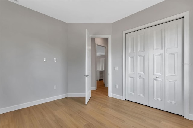 unfurnished bedroom with light hardwood / wood-style floors and a closet