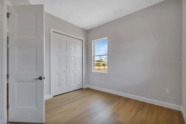 unfurnished bedroom featuring light hardwood / wood-style floors and a closet