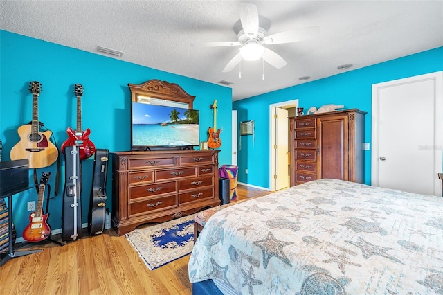 bedroom with hardwood / wood-style floors, a textured ceiling, and ceiling fan