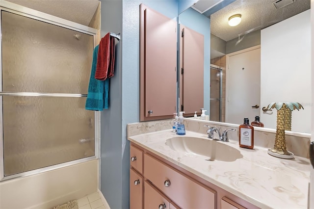 bathroom with vanity, tile patterned flooring, a textured ceiling, and enclosed tub / shower combo