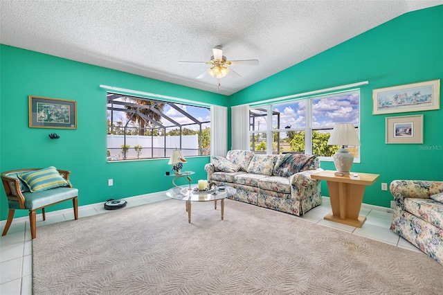 living area with a healthy amount of sunlight, ceiling fan, vaulted ceiling, and a textured ceiling