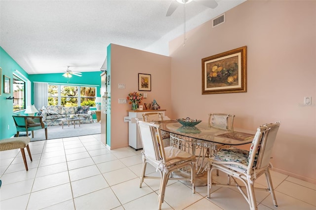 dining space featuring light tile patterned floors, a textured ceiling, ceiling fan, and vaulted ceiling