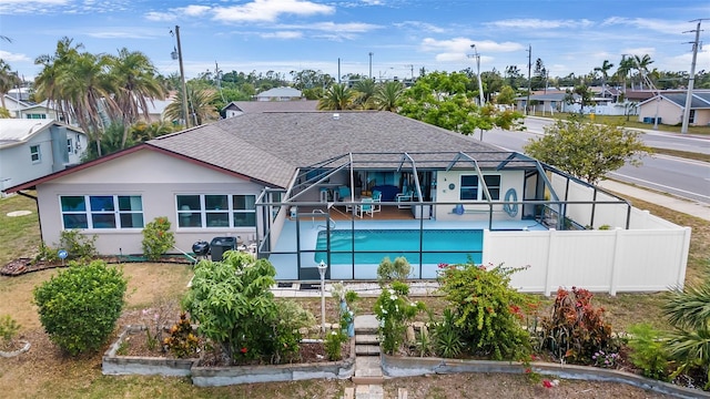 back of property featuring a patio area and glass enclosure