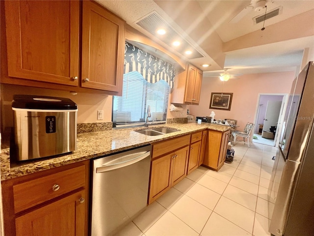 kitchen featuring appliances with stainless steel finishes, kitchen peninsula, light tile patterned floors, light stone counters, and sink