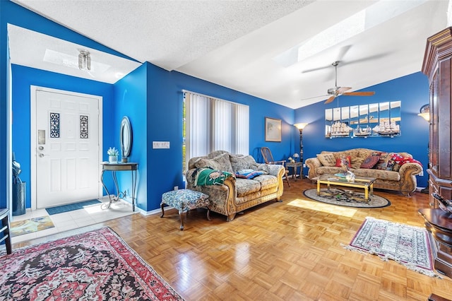 living room with lofted ceiling, a textured ceiling, ceiling fan, and parquet flooring