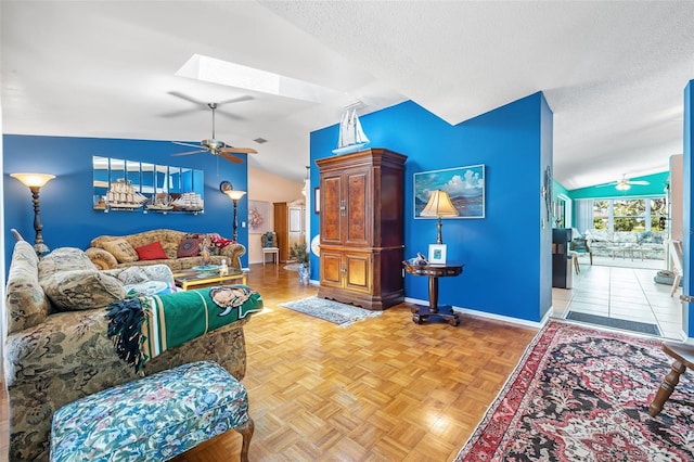 living room featuring a textured ceiling, ceiling fan, vaulted ceiling with skylight, and parquet floors