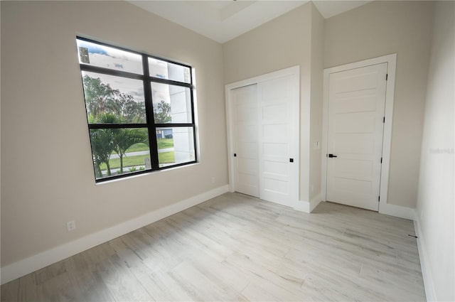 unfurnished bedroom with a closet and light wood-type flooring