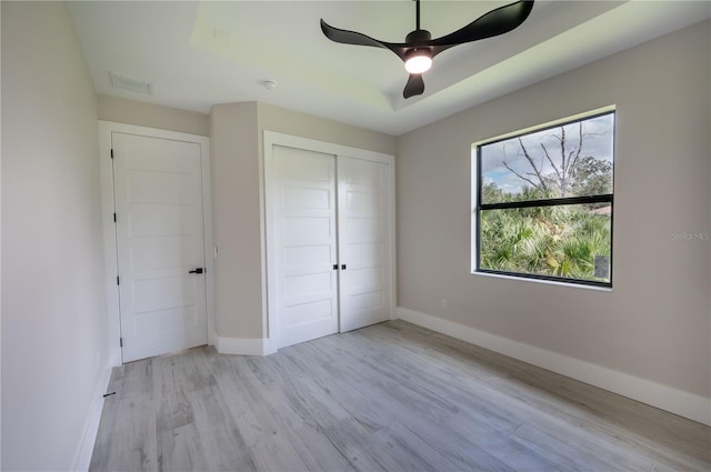 unfurnished bedroom with a closet, light wood-type flooring, and ceiling fan