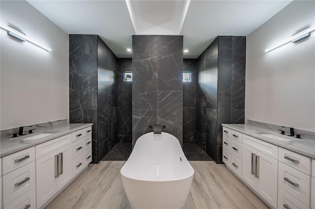 bathroom with hardwood / wood-style floors, vanity, and tile walls