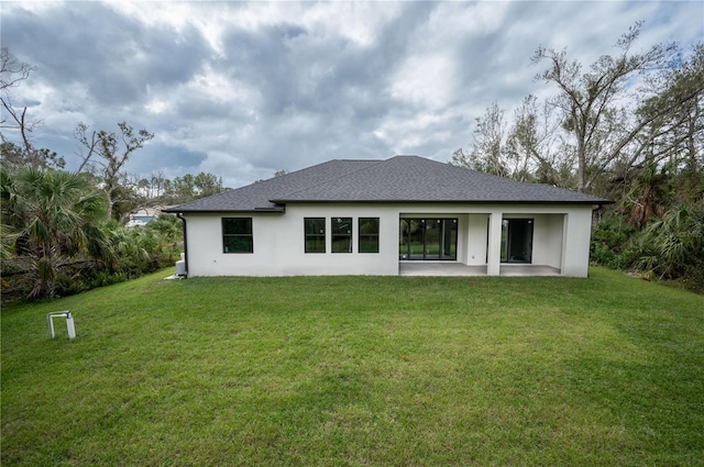 rear view of house featuring a patio and a yard