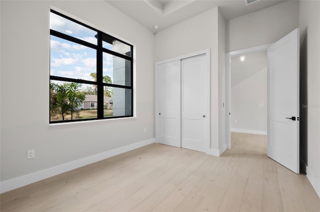 unfurnished bedroom with a closet and light hardwood / wood-style flooring