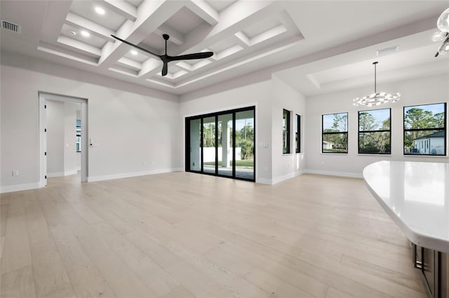 empty room with a towering ceiling, ceiling fan with notable chandelier, beamed ceiling, coffered ceiling, and light wood-type flooring