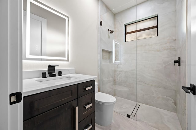 bathroom with vanity, a tile shower, and toilet