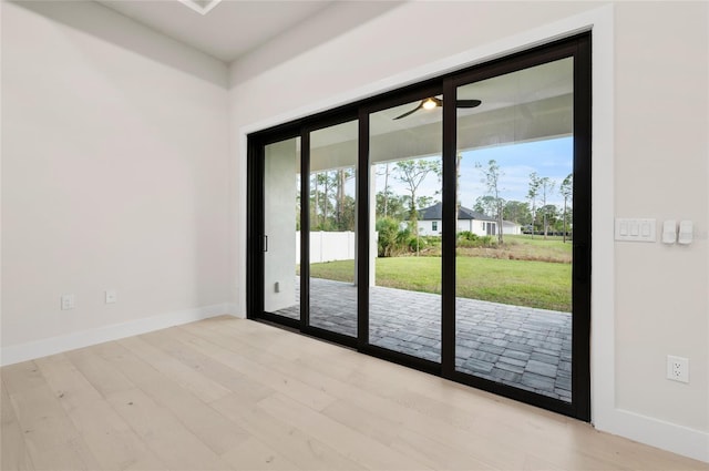 empty room with ceiling fan and light hardwood / wood-style flooring