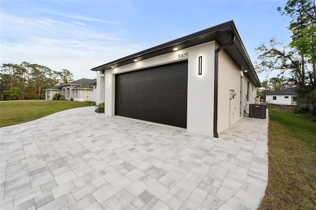 garage with a yard and central AC