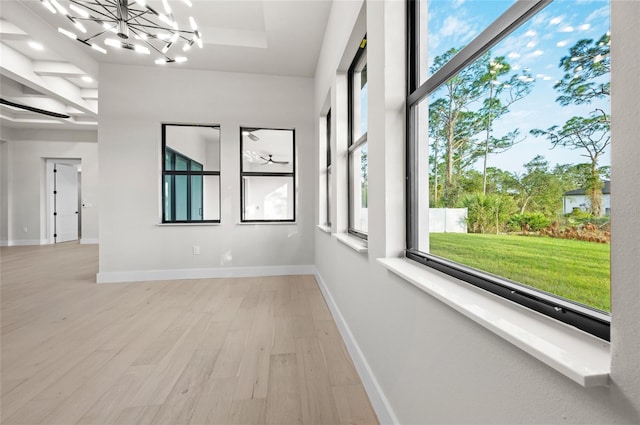 unfurnished sunroom with plenty of natural light and a chandelier