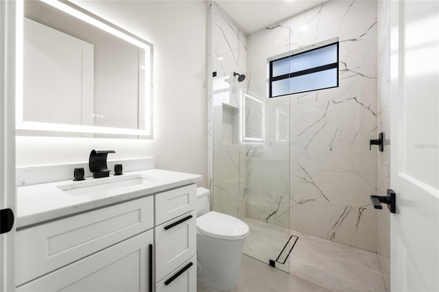 bathroom featuring vanity, a tile shower, and toilet