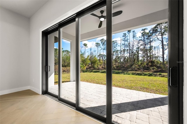 doorway to outside featuring ceiling fan and light parquet flooring