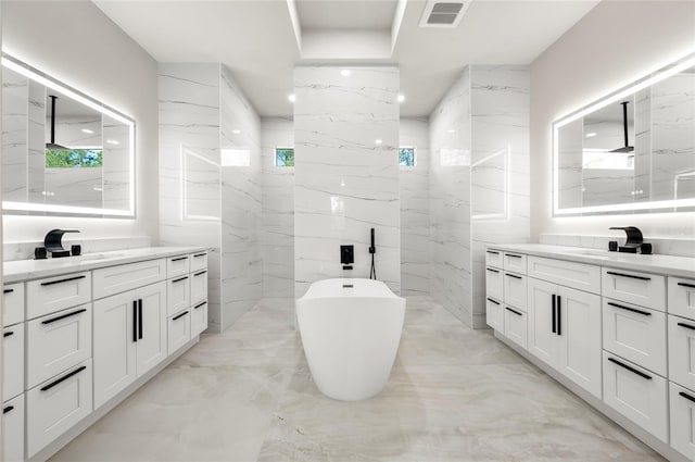 bathroom with vanity, a healthy amount of sunlight, tile walls, and plus walk in shower