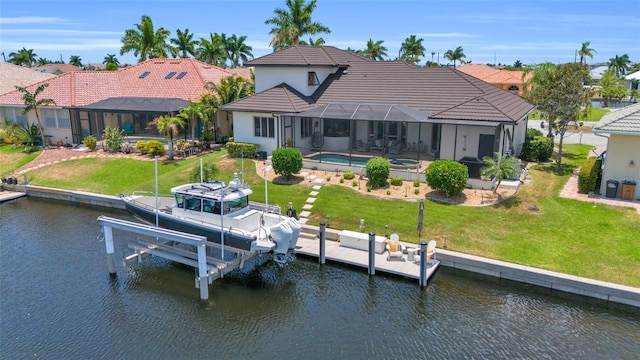 rear view of property featuring a water view, a lanai, and a lawn