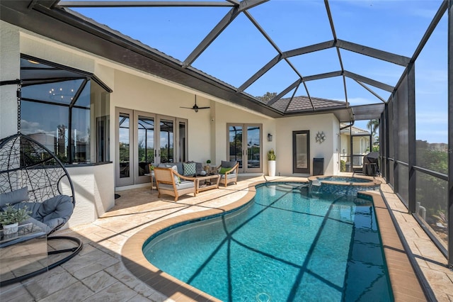 view of pool featuring glass enclosure, french doors, ceiling fan, an in ground hot tub, and a patio area