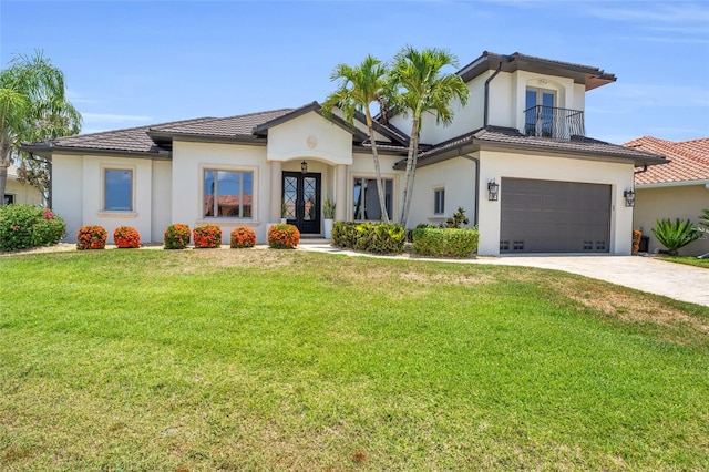 mediterranean / spanish home with a garage, a front yard, and french doors