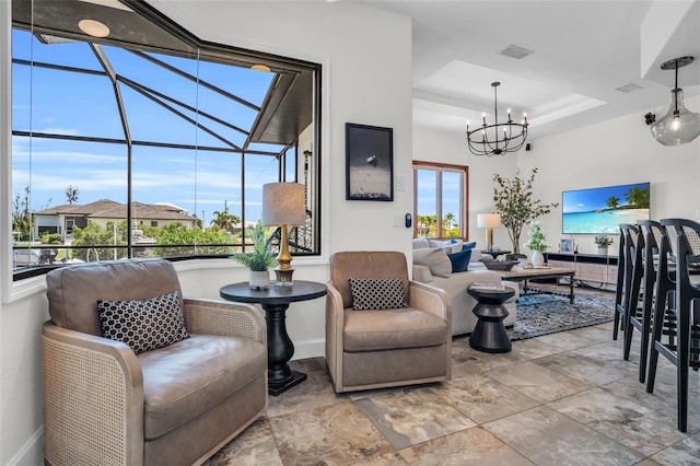 living room with a tray ceiling and a notable chandelier