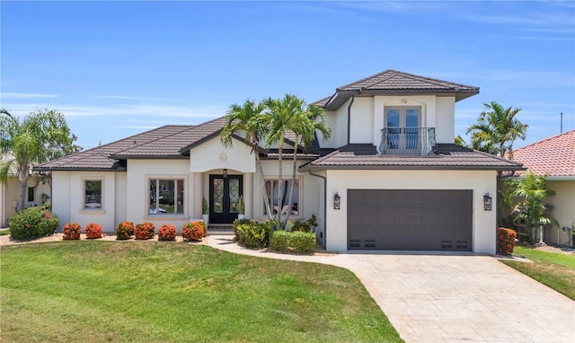 mediterranean / spanish house featuring french doors, a front yard, and a garage