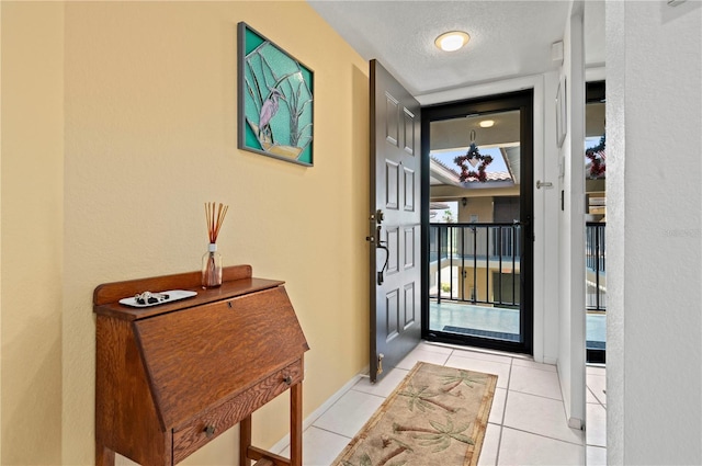 doorway to outside featuring light tile patterned floors and a textured ceiling