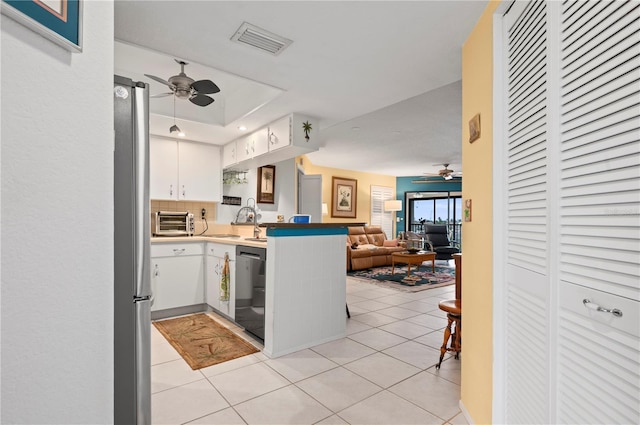 kitchen with kitchen peninsula, white cabinetry, black dishwasher, and light tile patterned floors