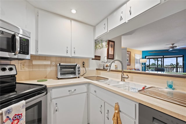 kitchen featuring ceiling fan, white cabinetry, stainless steel appliances, and tasteful backsplash