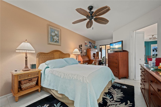 bedroom with ceiling fan, light tile patterned floors, and a closet