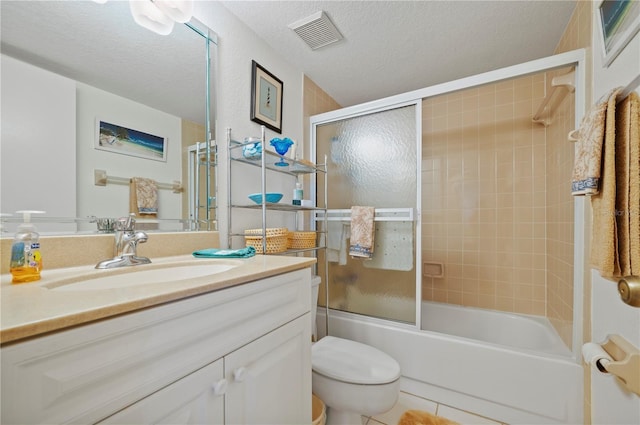 full bathroom with vanity, tile patterned flooring, toilet, enclosed tub / shower combo, and a textured ceiling