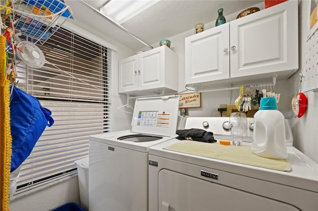 clothes washing area with cabinets and washing machine and dryer