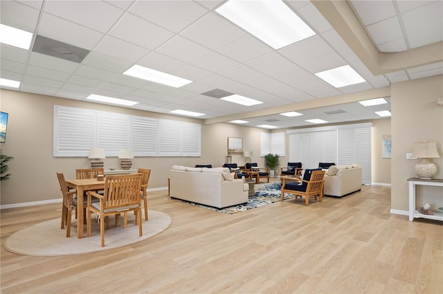 living room featuring a paneled ceiling and light wood-type flooring