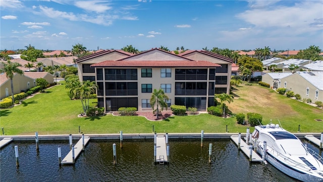 back of house with a lawn and a water view