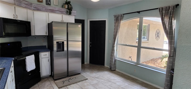 kitchen with light tile patterned floors, black appliances, and white cabinets