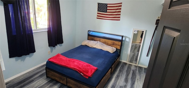 bedroom with dark hardwood / wood-style flooring