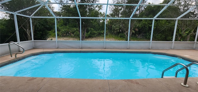 view of pool with a patio and glass enclosure