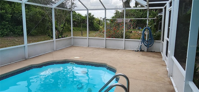 view of swimming pool featuring glass enclosure and a patio area