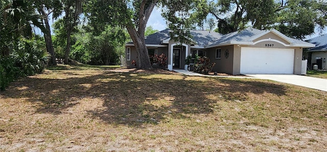 single story home with driveway, a front yard, a garage, and stucco siding