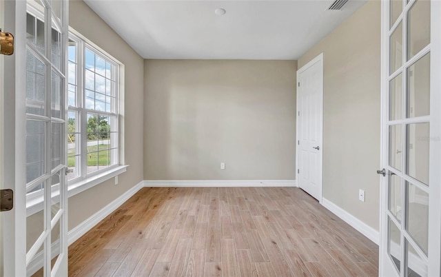 spare room with french doors and light wood-type flooring