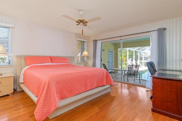 bedroom with access to exterior, a sunroom, multiple windows, and light wood-style floors