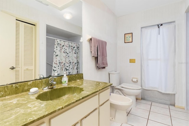 bathroom featuring vanity, a closet, tile patterned flooring, and toilet