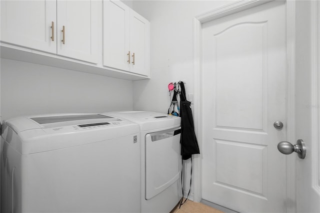 clothes washing area with cabinets, light tile flooring, and washing machine and dryer