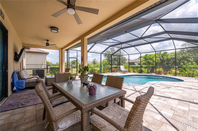 view of swimming pool with ceiling fan, glass enclosure, and a patio