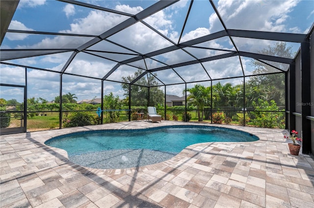 view of pool with glass enclosure and a patio area