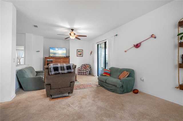 carpeted living room with ceiling fan